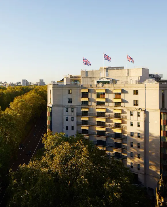 The Dorchester building exterior at sunset next to Hyde Park, London